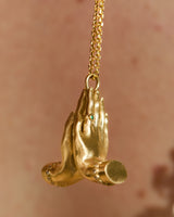 side view 14K gold Namaste necklace featuring sculpted praying hands with natural diamonds, emerald and ruby.