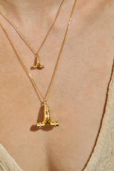 Sculpted praying hands charm in 14K gold on a fine chain, diamond-set bands, layered close-up