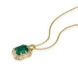 Angled view of emerald-cut natural emerald and diamond necklace with textured 14K yellow gold setting.