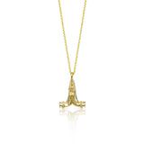 Mini Namaste gold necklace featuring sculpted praying hands with a natural emerald and diamond.