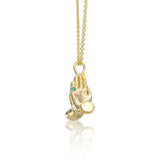 Side view of the Mini Namaste necklace showing the sculptural gold pendant and fine chain.