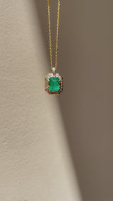 Emerald-cut natural emerald and diamond necklace in hand-carved 14K yellow gold, featuring a deep green center stone surrounded by natural diamonds.
