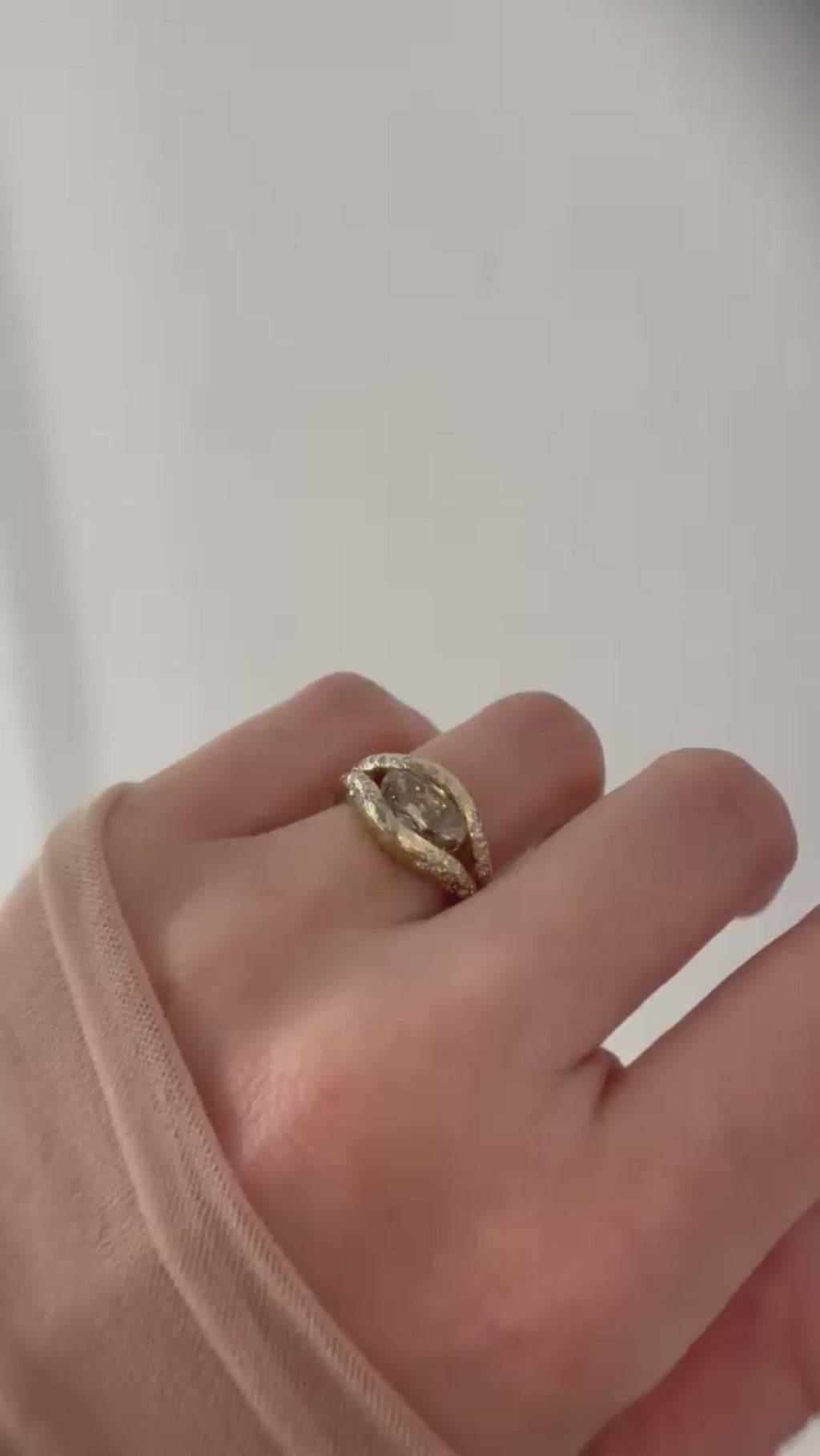 Oval-shaped champagne diamond halo ring in textured 14K gold with a floating diamond effect and diamond halo
