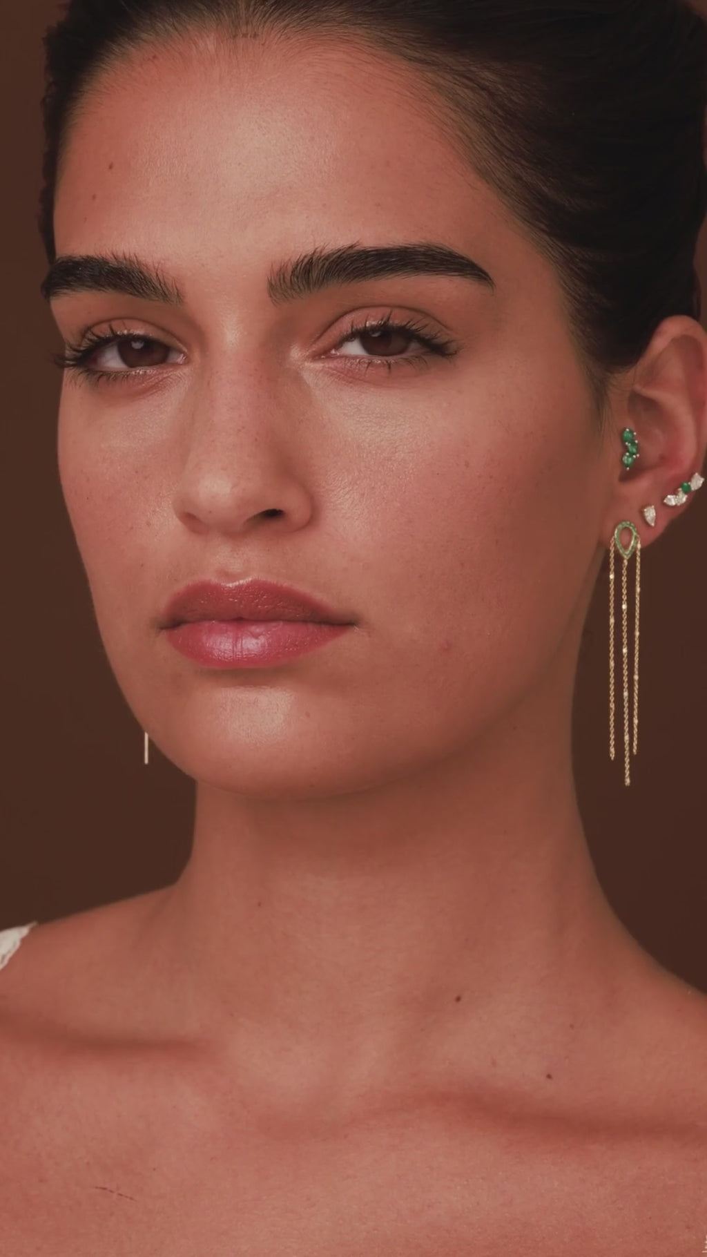 video of model wearing rosa emerald thin chain earrings with diamond and emerald studs
