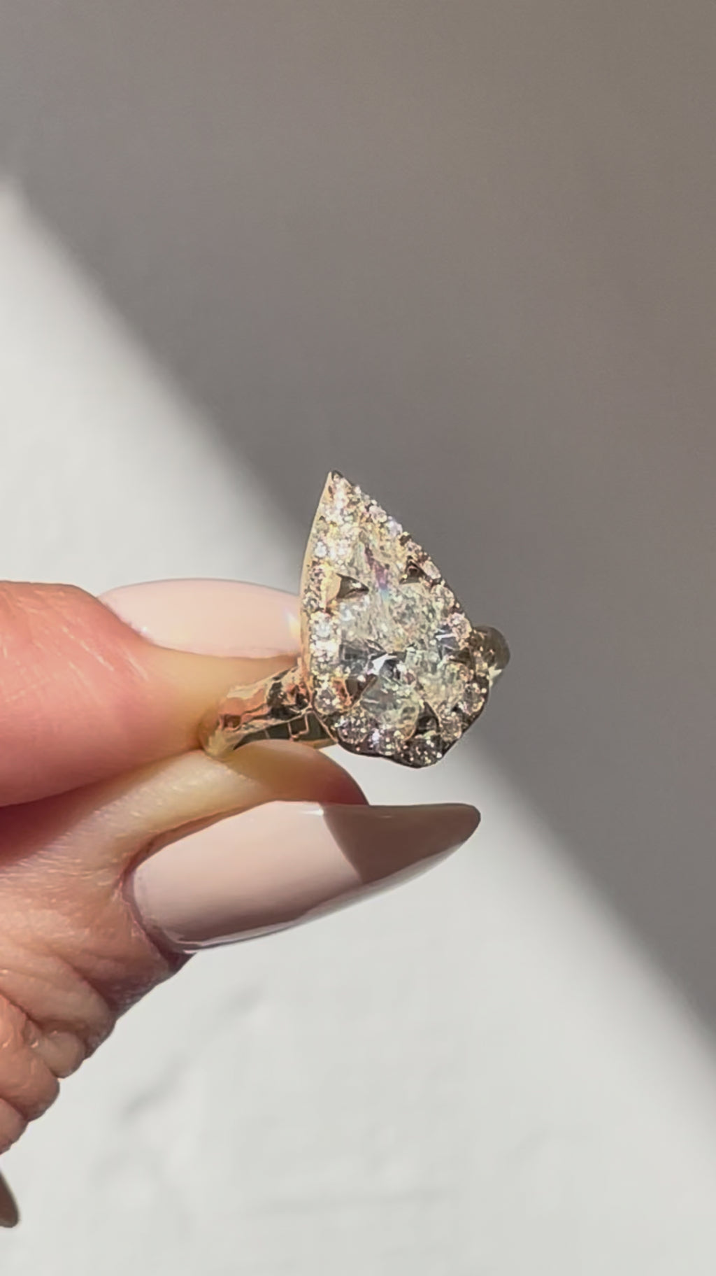 video of 2 CT pear diamond halo engagement ring with a sculptural textured gold band.