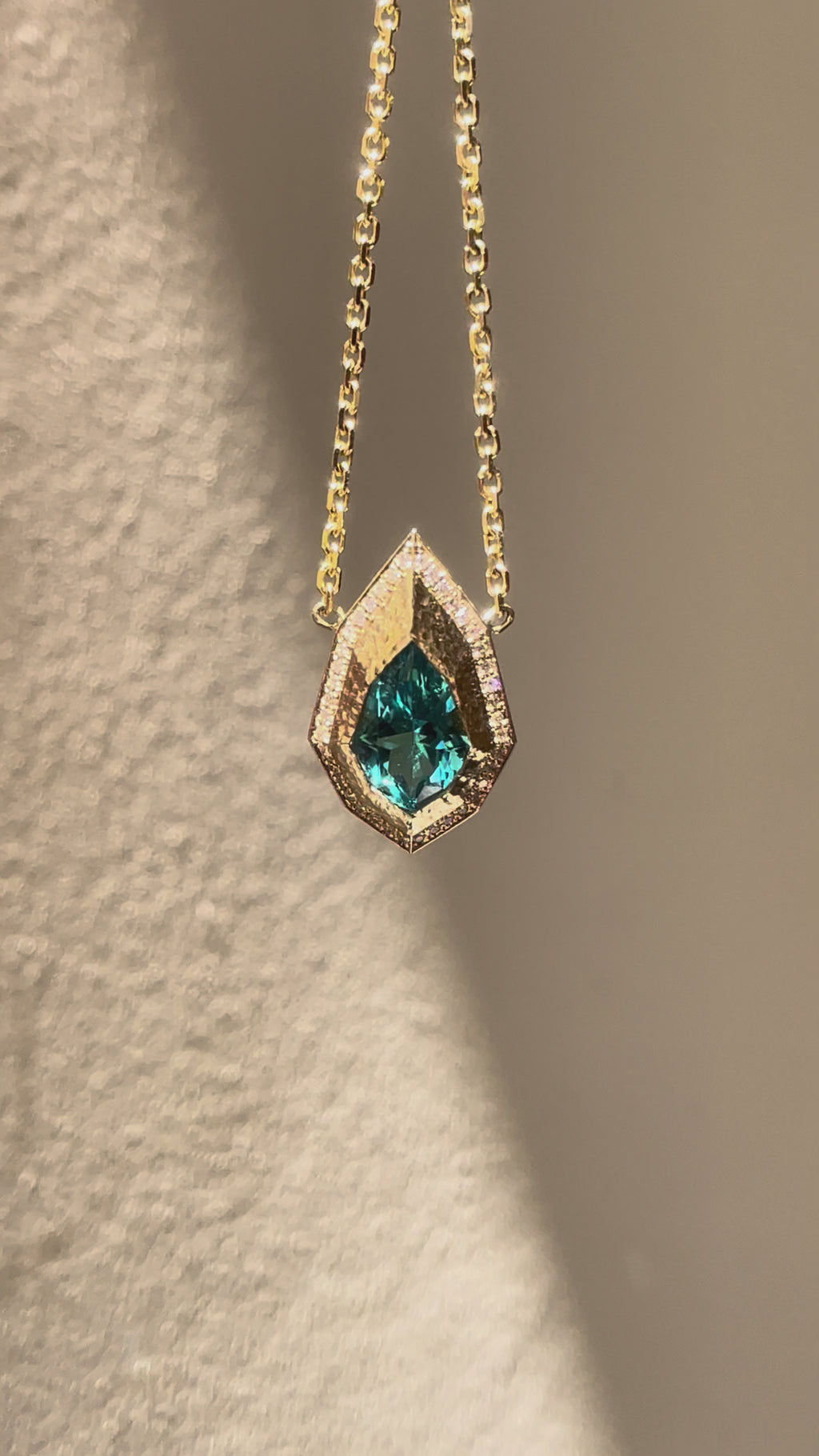 Pear-cut lagoon tourmaline and natural diamond necklace in hand-carved 14K yellow gold, featuring an Art Deco inspired geometric pendant.