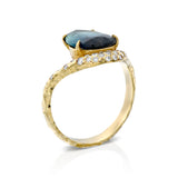 Angled view of multicolor tourmaline and diamond halo ring with sculptural textured 14K gold band.